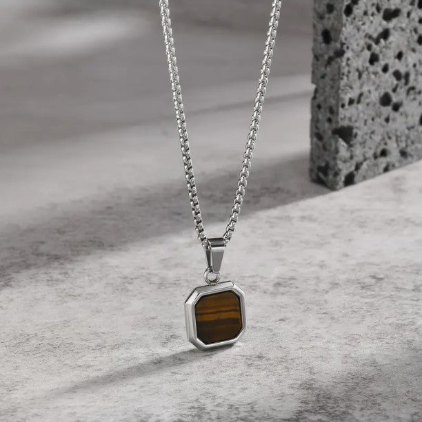 Cadena Veneciana con Ojo de Tigre (Dije) en fondo urbano de piedra