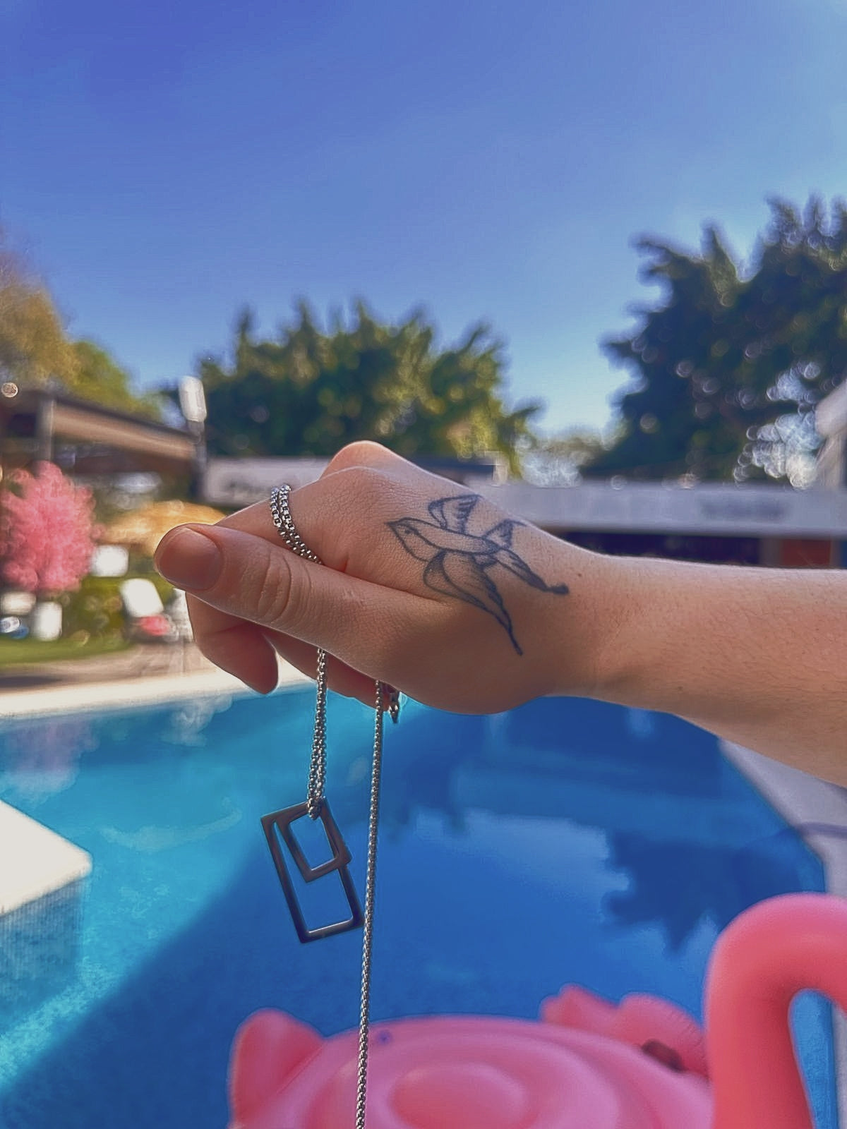 Mano tatuada sosteniendo collar de hombre El Salvador